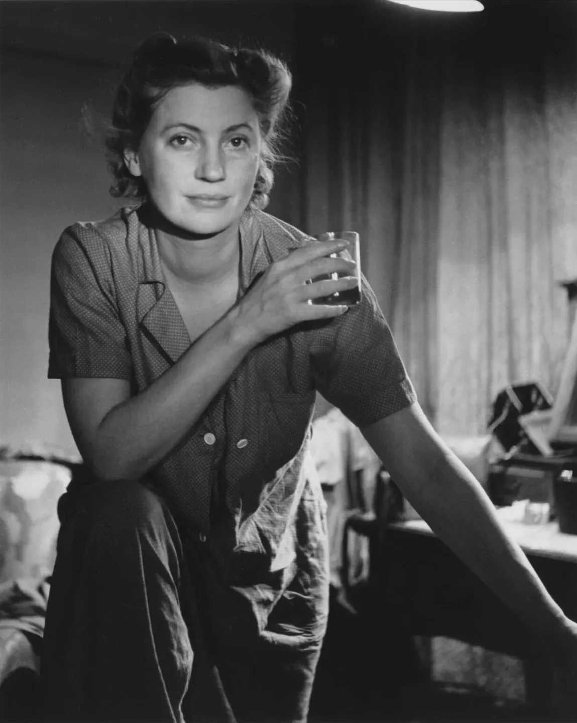 Lee Miller, portrait un verre à la main.